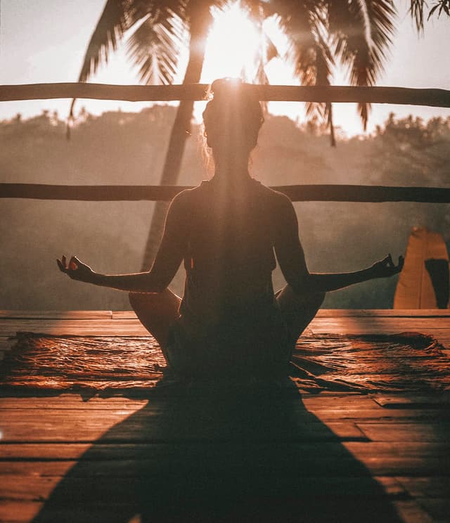 Group yoga practice at sunrise on the banks of the Ganges in Rishikesh